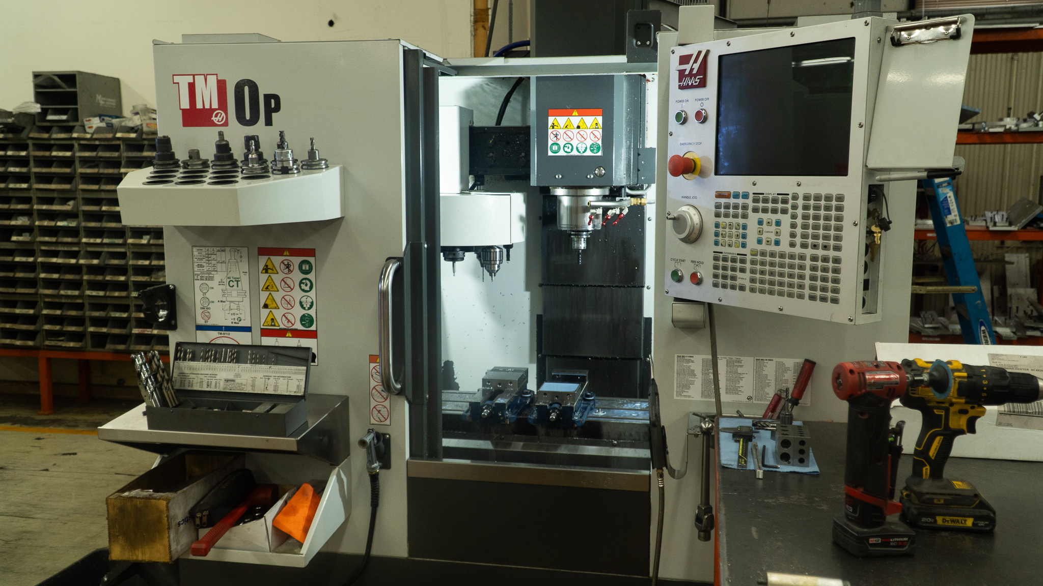 Close-up of a machine in operation, highlighting its moving components and active controls. The image captures the machine in action, showcasing intricate details such as gears, spindles, and automated parts. Emphasizes high-performance industrial equipment and precision manufacturing processes in an active workshop setting