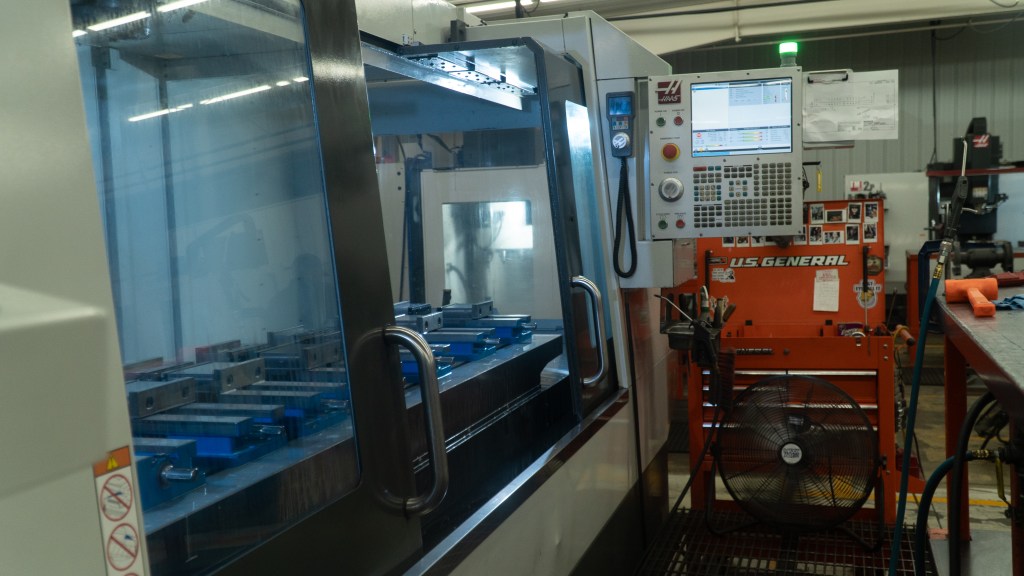 Close-up photo of a precision machine in a machine shop, highlighting detailed components and advanced features. The image focuses on the intricate parts of the machinery, including gears and controls, emphasizing high-quality craftsmanship and the state-of-the-art technology used in industrial manufacturing.